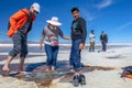 Happy tourists enjoy Jeep tour activities in Salt flats Salar de Uyuni in Bolivia